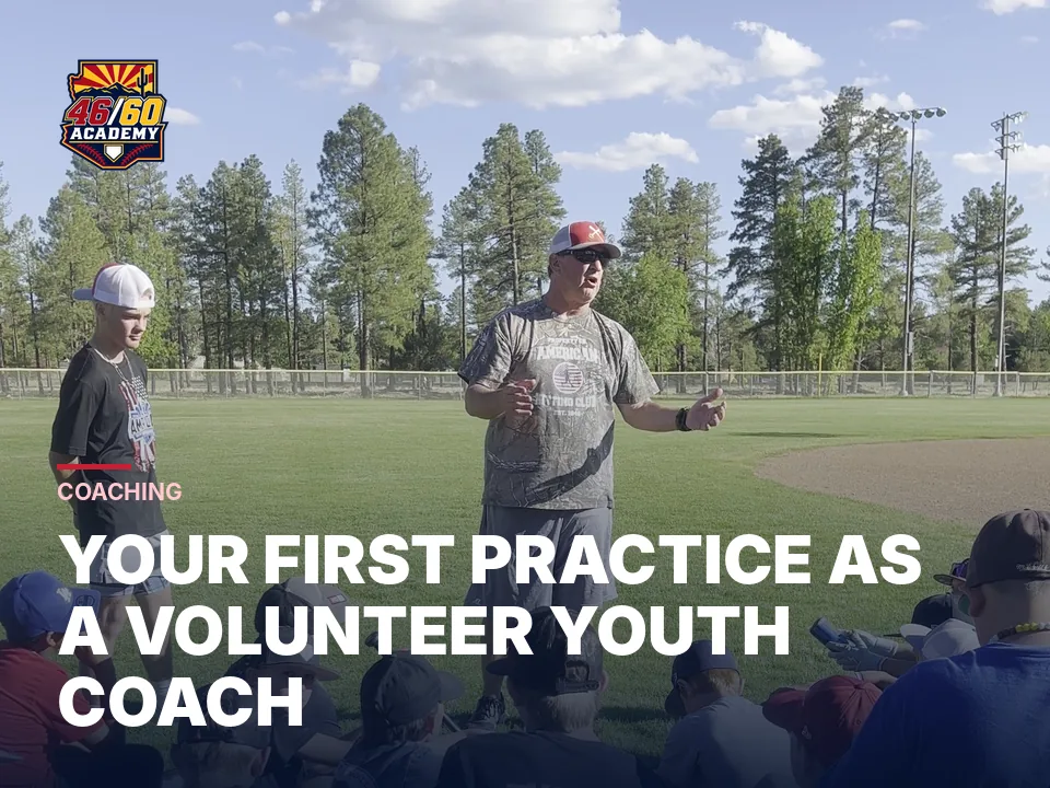 Coach BK talking to a group of young players seated on the grass at camp