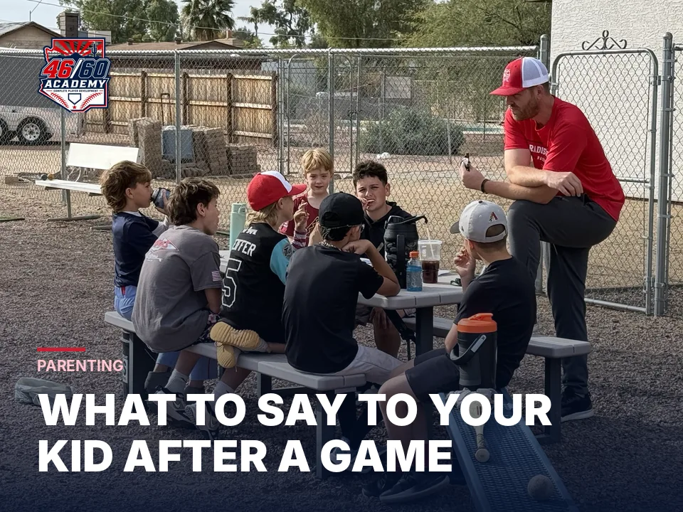 Coach talking with young players around a table between sessions